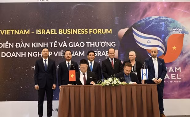 The signing of a cooperation document at the forum. (Photo: VNA)