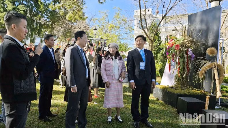 Chairman of the Da Lat Flower Association Phan Thanh Sang (right) introduces the exhibition works to delegates.