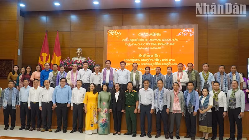 Provincial leaders of Dong Thap take souvenir photos with the delegation from Champasak Province (Laos). (Photo: HUU NGHI)