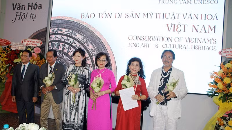 Pham Hoang Thinh (far left), Head of the Representative Office of the Vietnam Union of UNESCO Associations in Ho Chi Minh City handed over the decision and congratulated the Centre's Board of Directors.