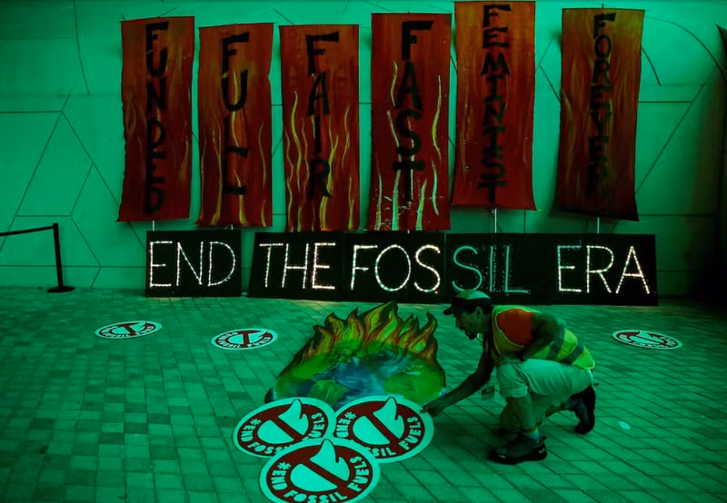 A climate activist arranges artwork against fossil fuels at Dubai's Expo City during the United Nations Climate Change Conference COP28 in Dubai, United Arab Emirates, December 12, 2023. (Photo: REUTERS)