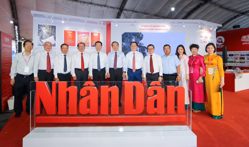 Delegates visit a booth displaying publications of Nhan Dan (People) Newspaper at the event