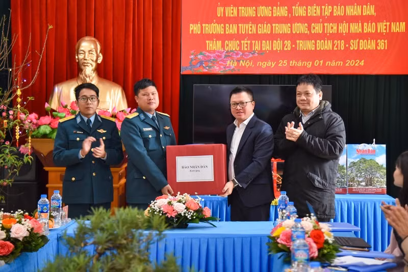 Nhan Dan Newspaper Editor-in-Chief Le Quoc Minh (third from left) presents gifts to air defence officers and soldiers ahead of Tet 