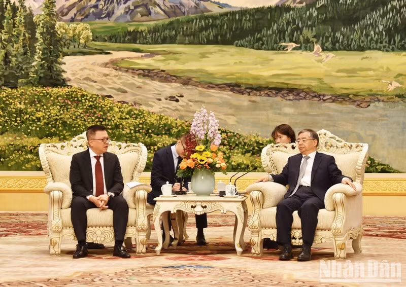 Head of the CPC Central Committee's Publicity Department Li Shulei (R) receives Nhan Dan Newspaper Editor-in-chief Le Quoc Minh 