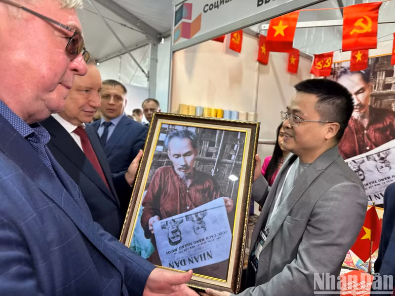 A representative of Nhan Dan Newspaper presented the Governor of Saint Petersburg with a painting featuring President Ho Chi Minh reading Nhan Dan Newspaper.
