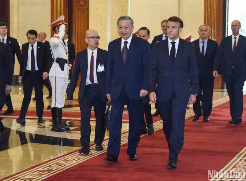 Vietnamese Party General Secretary To Lam (L) welcomes French President Emmanuel Macron