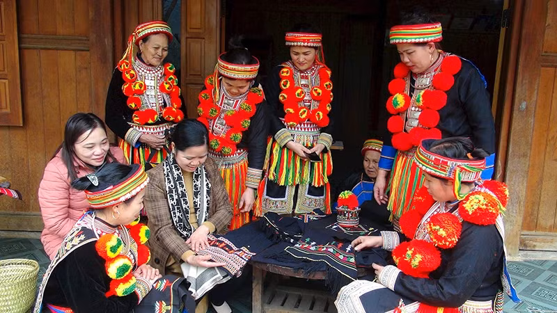 Dao ethnic women in Ban Cuon Village, Ngoc Phai Commune, Cho Don District, introduce traditional products to visitors (Photo: HUONG LIEU) 