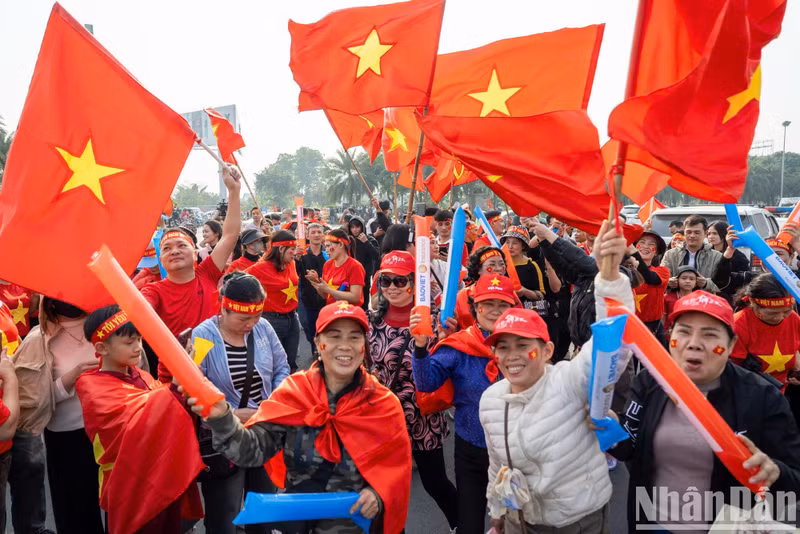 People proudly weaving red flags with golden stars to welcome the national men’s football team. People proudly weaving red flags with golden stars to welcome the national men’s football team.