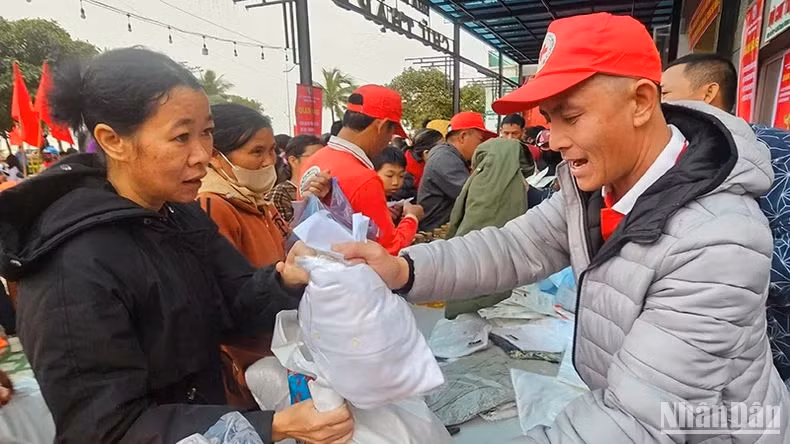 Volunteers from the Red Cross in Thanh Hoa Province present gifts to the poor.