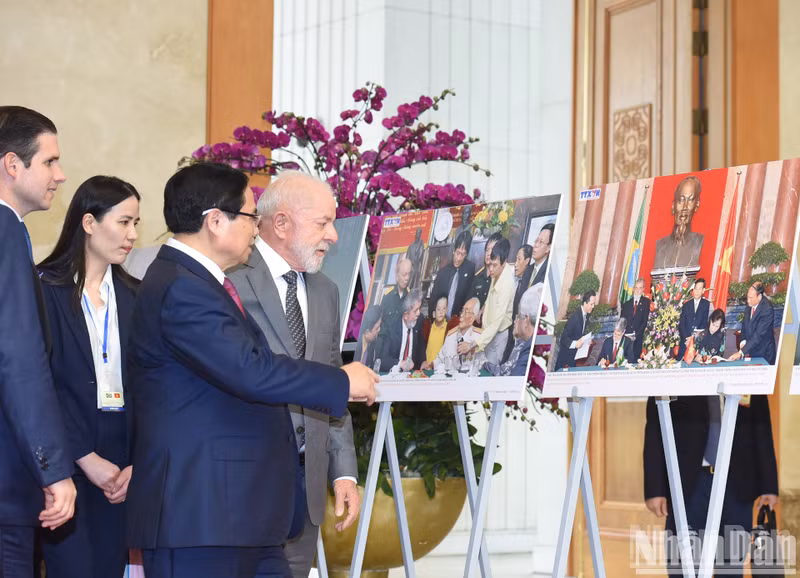 Prime Minister Pham Minh Chinh and Brazilian President Luiz Inacio Lula da Silva visit a photo exhibition on the two countries' cooperation on the sidelines of their meeting in Hanoi on March 28. (Photo: NDO/Tran Hai)