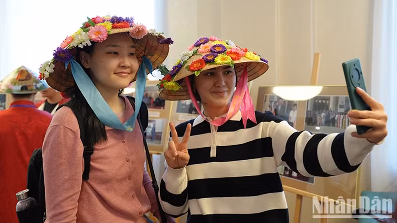 International students enjoy taking souvenir photos with Vietnamese conical hats.