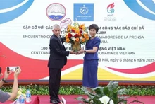 A representative of Prensa Latina News Agency in Viet Nam presents flowers to General Director of the Viet Nam News Agency Vu Viet Trang to congratulate the agency on the occasion of the 100th anniversary of Vietnamese Revolutionary Press Day. (Photo: VNA) 