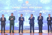 Prime Minister Pham Minh Chinh (third from right) and officials launch the Ministry of Construction’s new information technology systems at the conference on December 21. (Photo: NDO)