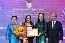 Cuban Consul General in Ho Chi Minh City Ariadne Feo Labrada (second, left) receives the “For peace and friendship among nations” insignia of the Viet Nam Union of Friendship Organisations at the event (Photo: VNA)