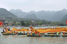 A procession of dragon boats carries sacred water from Tam Chuc Lake to Ngoc Mountain. (Photo: DAO PHUONG)