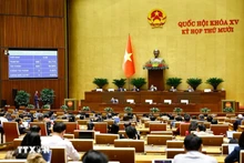 The National Assembly votes to adopt the law amending and supplementing several articles of the Law on International Treaties in Ha Noi on December 10 (Photo: VNA)