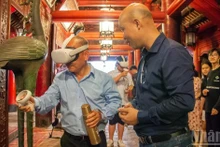 Tourists enjoy experiencing virtual reality systems at the Van Mieu–Quoc Tu Giam (Temple of Literature). (Photo: Ha Nam)