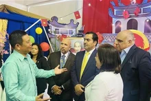 Vietnamese Ambassador to Venezuela Vu Trung My (left) and representatives of Santa María University at the “Viet Nam – Land and People” space during the 2025 International Student Festival. (Photo: VNA)
