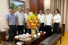 Politburo member Nguyen Trong Nghia congratulates journalist Dinh The Huynh. (Photo: VAN TOAN)