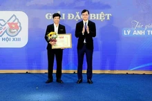 Bui Quang Huy, Member of the Party Central Committee and First Secretary of the Ho Chi Minh Communist Youth Union Central Committee (right), presents the Special Prize of the Logo Design Contest for the 13th National Youth Congress to Ly Anh Tuan.