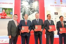 General Secretary To Lam and other Party and State incumbent and former leaders receive the book titled “Uncle Ho’s articles on Culture and Journalism by in Nhan Dan Newspaper” at the Nhan Dan exhibition’s pavilion.