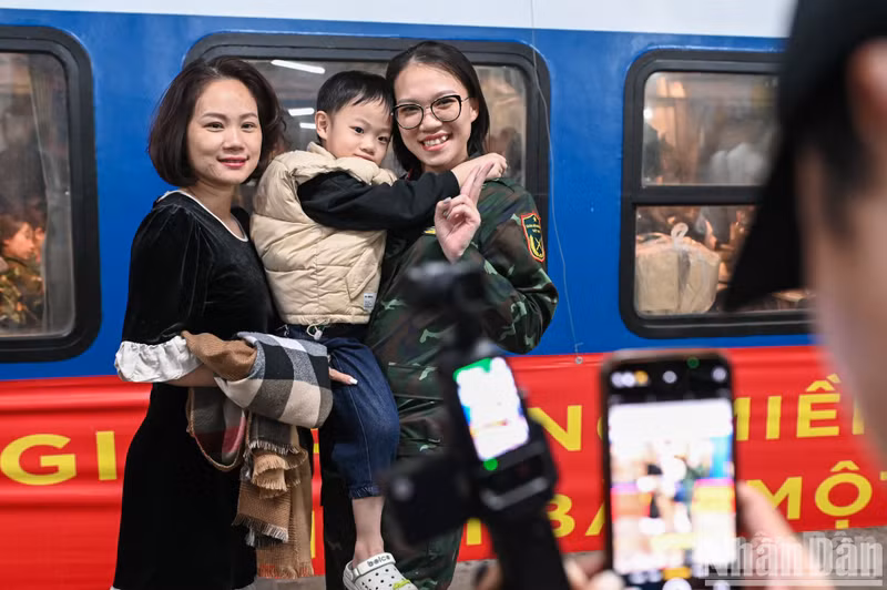 Female soldiers took souvenir photos with relatives before the train departed. Female soldiers took souvenir photos with relatives before the train departed.
