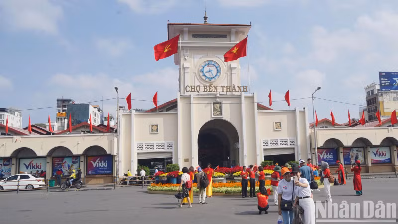 Locals and foreign visitors walk under the brilliant flags in front of Ben Thanh Market, everyone cannot hide their national pride in the historic April days.