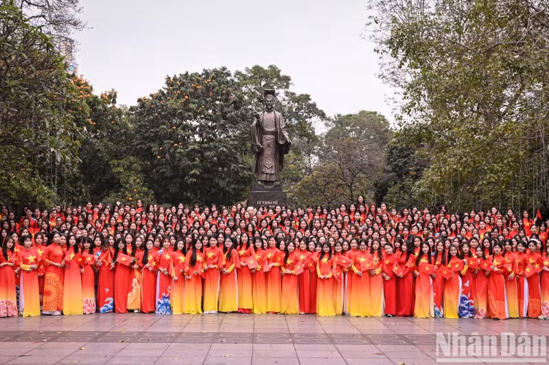 500 female students from the Vietnam Women's Academy wearing Ao Dai with the red flag and yellow star took photo at the Ly Thai To monument.