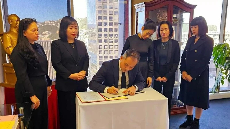 Ambassador Phan Minh Giang writes the condolence book for former President Tran Duc Luong (Photo: Vietnamese Embassy in New Zealand)
