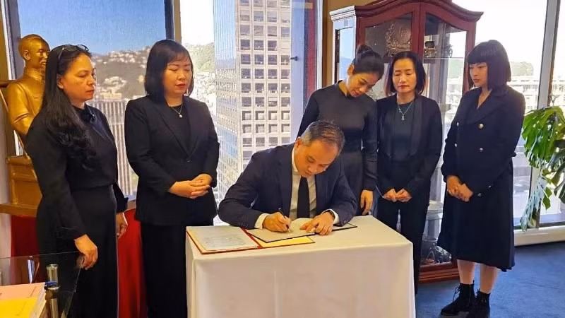 Ambassador Phan Minh Giang writes the condolence book for former President Tran Duc Luong (Photo: Vietnamese Embassy in New Zealand)