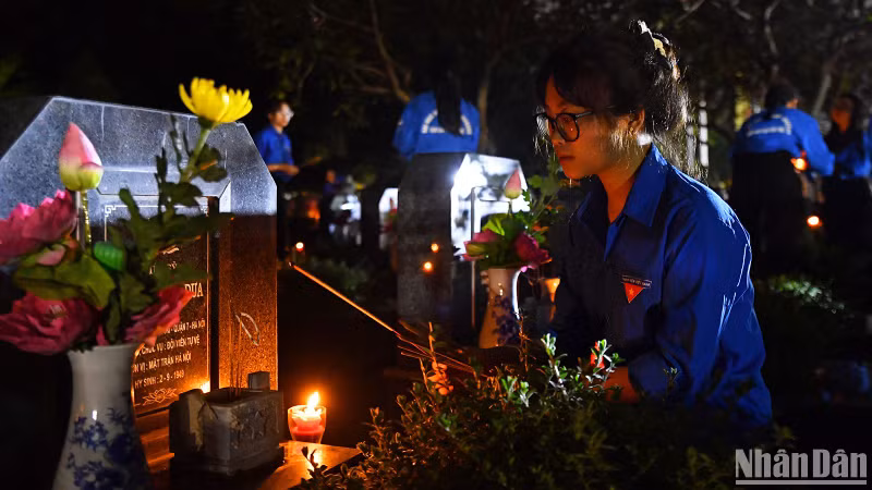 Youth union members light incense at Mai Dich Cemetery.