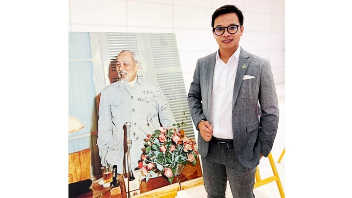 Assoc.Prof.Dr. Tran Le Hung beside a photo of Uncle Ho at the 4th World Conference of Overseas Vietnamese in 2024.