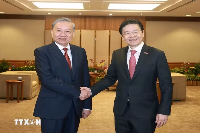 Singaporean Prime Minister and PAP Secretary-General Lawrence Wong (R) welcomes Vietnamese Party General Secretary To Lam on official visit to Singapore. (Photo: VNA)