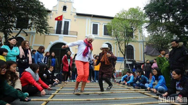 Foreign tourists enjoy a folk cultural activity in Ha Noi (Photo: Nhan dan Newspaper)