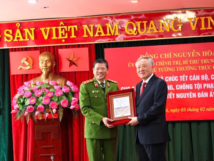 Lieutenant General Tran Minh Le, Director of the Environmental Police Force, presents Permanent Deputy Prime Minister Nguyen Hoa Binh with a print of the painting ‘Cover of Future’ about environmental protection. (Photo: TAM PHAM)