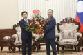 Vietnamese Ambassador to Laos Nguyen Minh Tam (R) hands over flowers from Prime Minister Le Minh Hung to congratulate Lao PM Saleumxay Kommasith. (Photo: VNA)