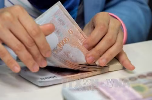 Counting Thai baht at Krung Thai Bank in Bangkok. (Photo: AFP/VNA)