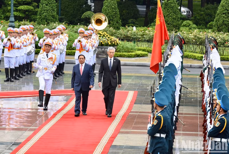 Prime Minister Pham Minh Chinh and his Singaporean counterpart Lee Hsien Loong review the guard of honour. (Photo: Tran Hai)