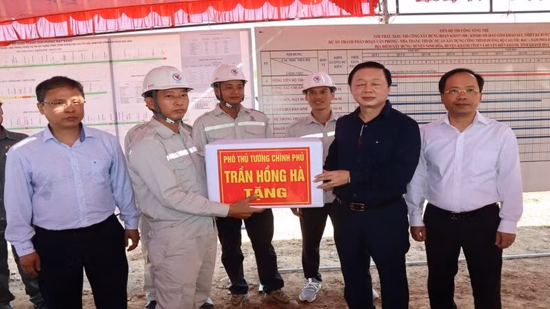 Deputy PM Tran Hong Ha presents gifts to workers and engineers at the construction site.