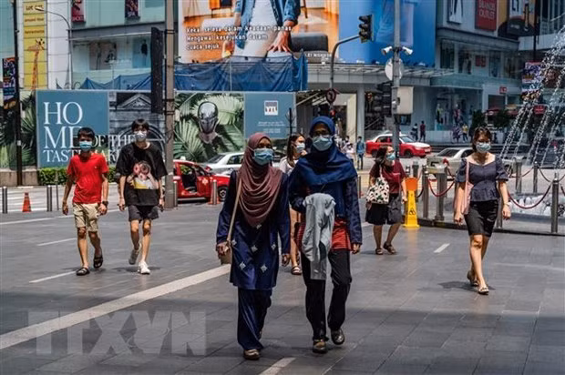 People walk on a street in Kuala Lumpur (Photo: AFP/VNA)