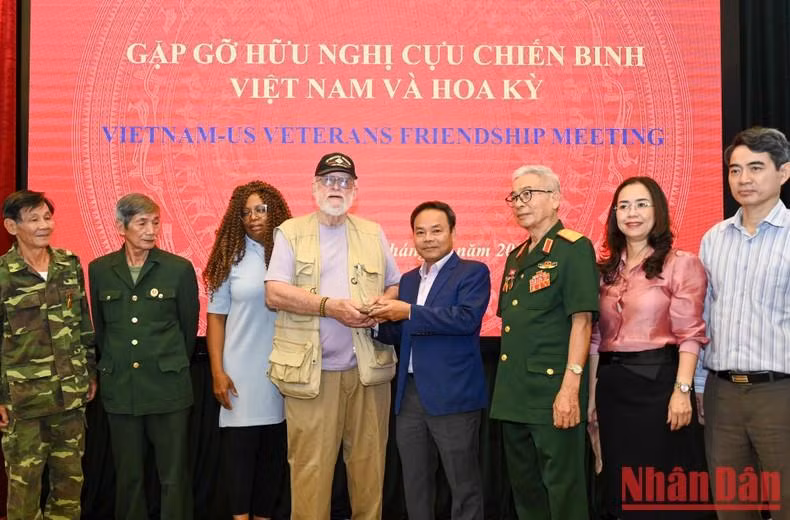 Nhan Dan’s Deputy Editor-in-chief Dinh Nhu Hoan receives the belongings of a Vietnamese soldier from American veteran Steve Edmunds. (Photo: Duy Linh)