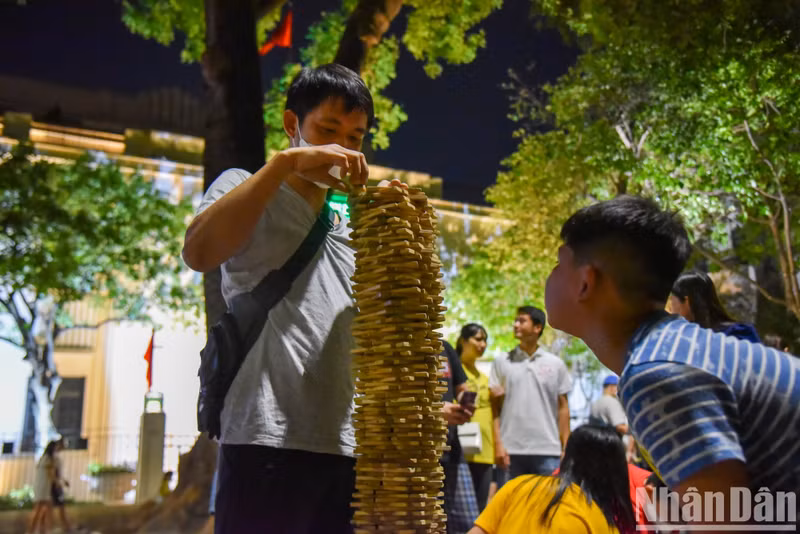 A man building a Jenga tower, something which requires patience and accuracy.