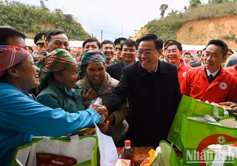 National Assembly Chairman Vuong Dinh Hue shakes hands with members of the ethnic community in Trinh Tuong.