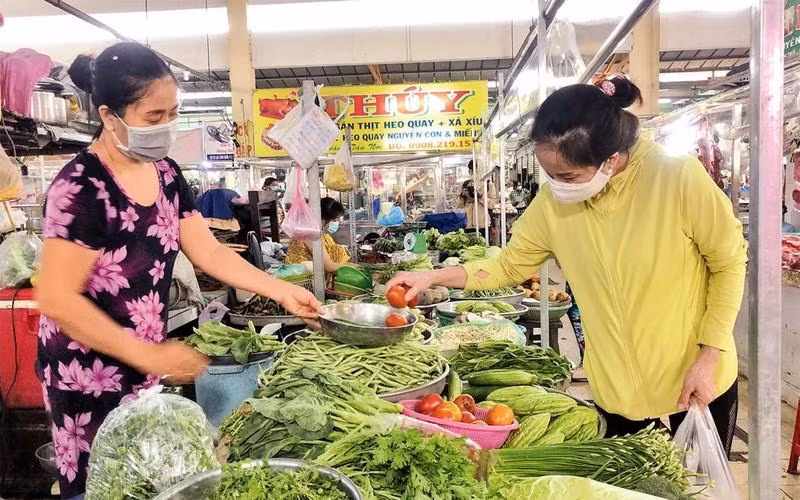 A woman shops for vegetables at a market in Ho Chi Minh City. (Photo: NDO)