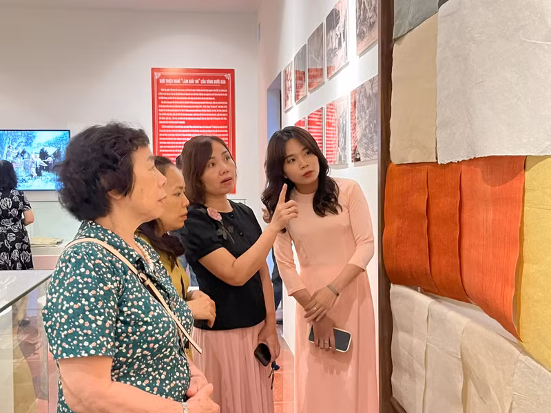 Visitors learn about 'Do' paper at an exhibition.
