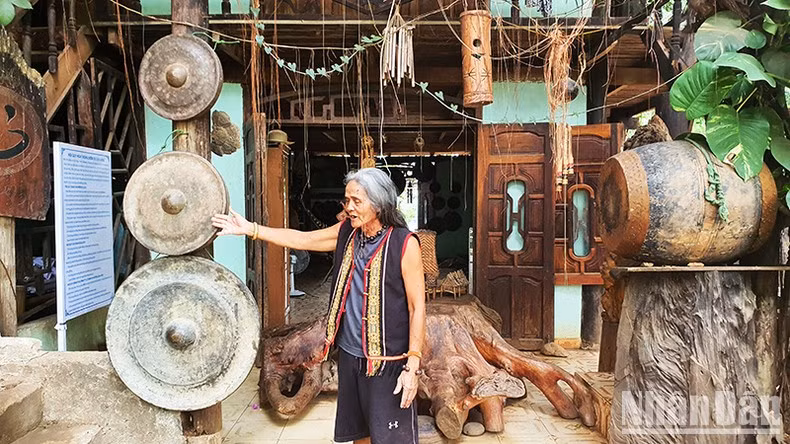 A Biu enthusiastically introduces his gong collection to tourists. A Biu enthusiastically introduces his gong collection to tourists.