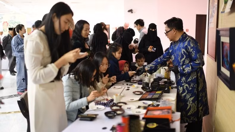 Visitors experience crafting handmade items such as necklaces, bracelets, plates, and cups using traditional Vietnamese lacquer art.