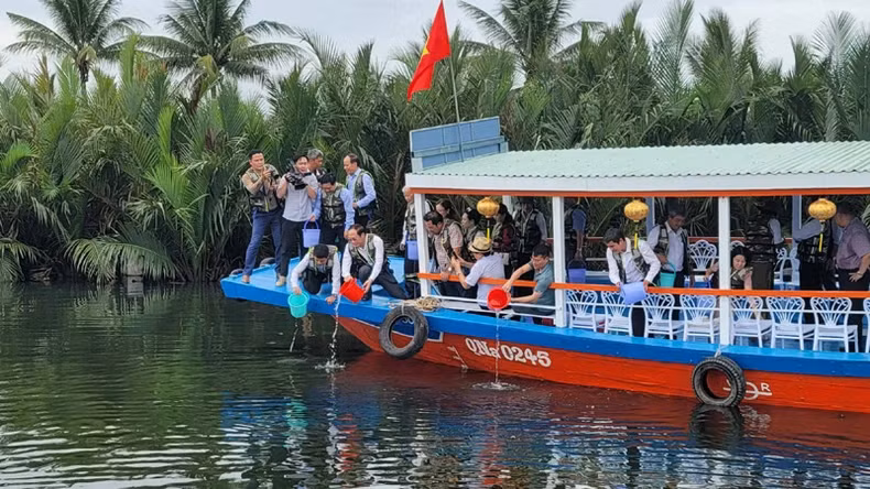 The delegates release fish to supplement native and endemic aquatic species into natural waters in Hoi An.