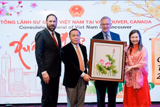  Consul General Nguyen Quang Trung (second, left) presents a gift to representatives of the British Columbia government. (Photo: VNA) 