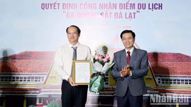 Director of Lam Dong Provincial Department of Culture, Sports and Tourism Nguyen Trung Kien presents the decision of the Lam Dong Provincial People's Committee to recognise the Da Lat Railway Station as a tourist destination to representative of the Vietnam Railways Corporation.